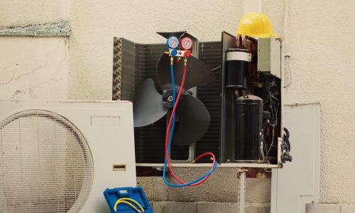 Zoom in shot of damaged external air cooling unit with protection cover removed in need of repairing, with malfunctioning internal parts. Outside condenser not working anymore, ready to be repaired